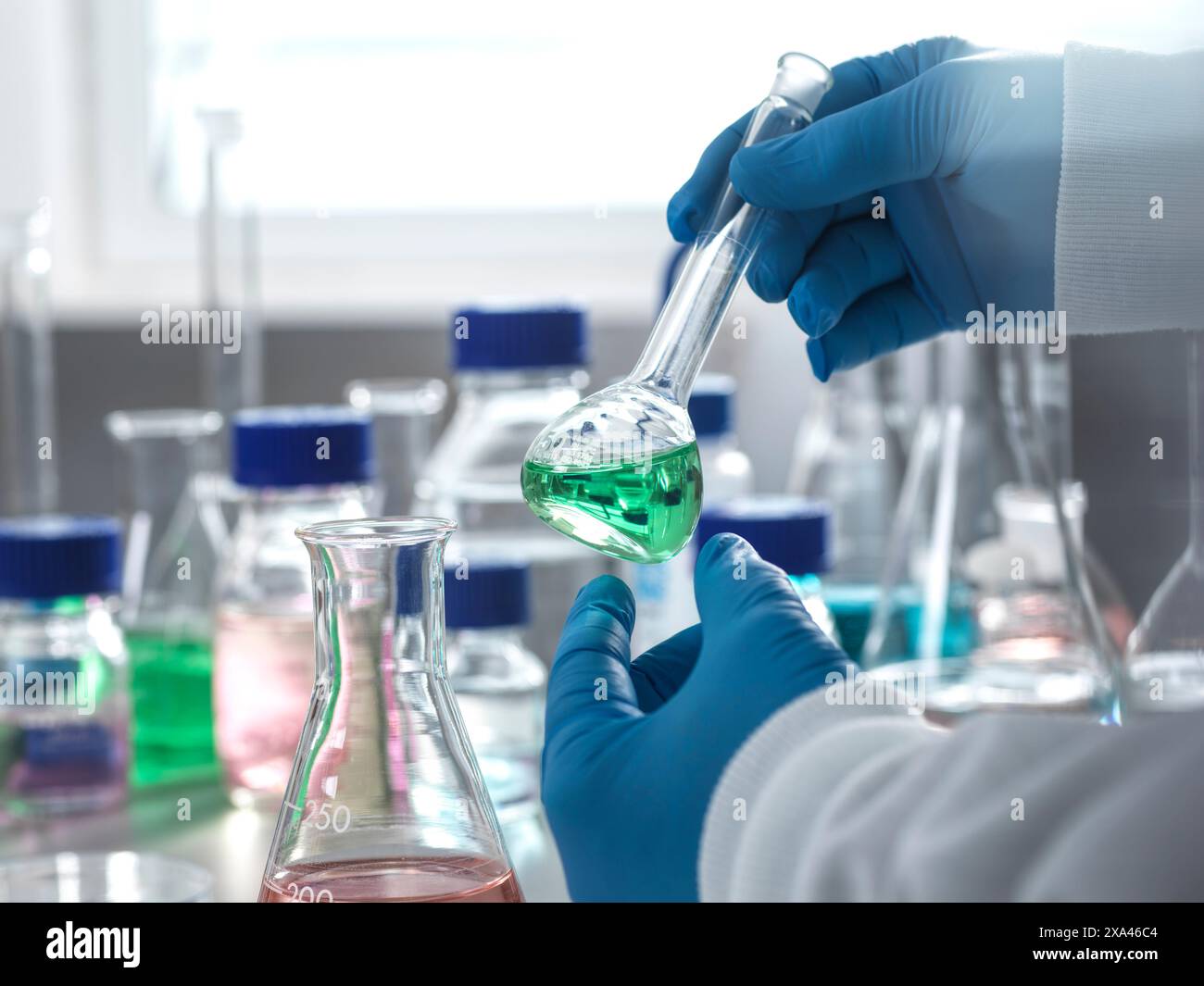 Wissenschaftler, der im Labor Flüssigkeit in den Kolben gießt Stockfoto
