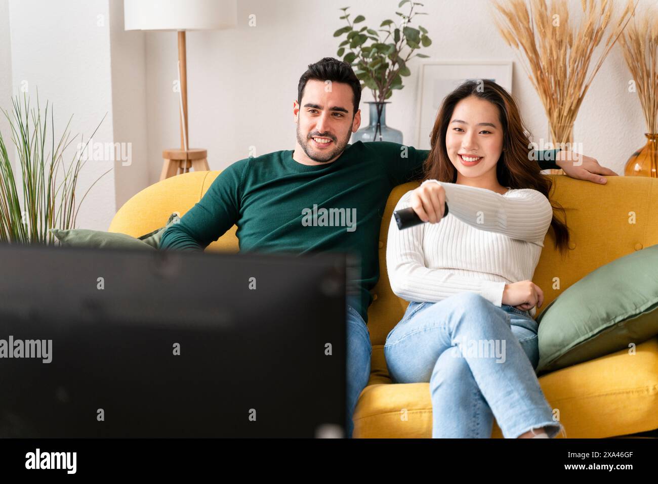 Zu Hause entspannen Sie sich auf einem gelben Sofa Stockfoto