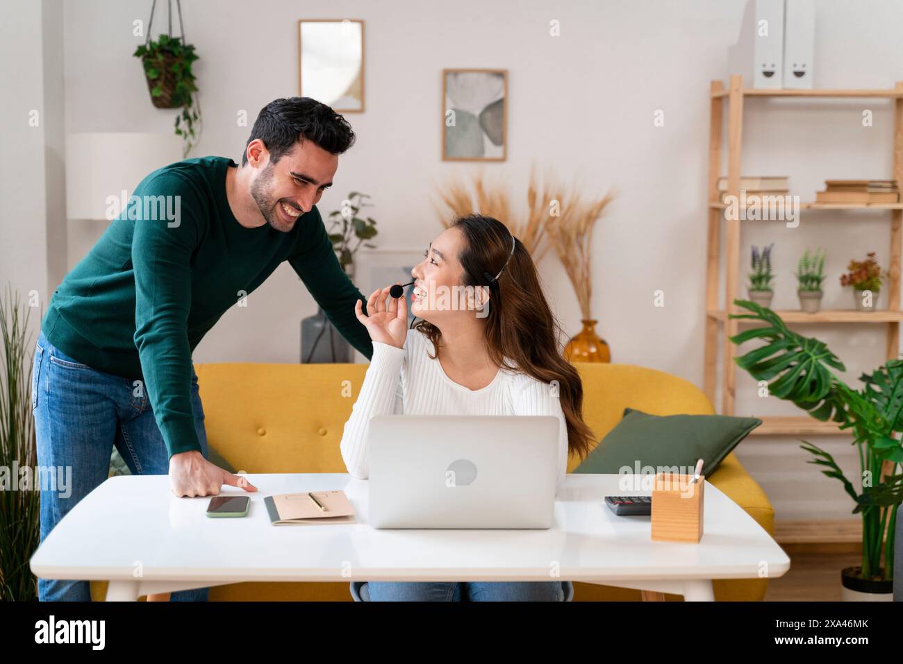 Mann, der Frau einen Snack in einem gemütlichen Heimbüro gibt. Stockfoto