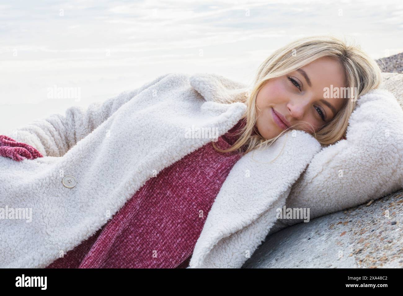 Junge Frau im Winter am Strand Stockfoto