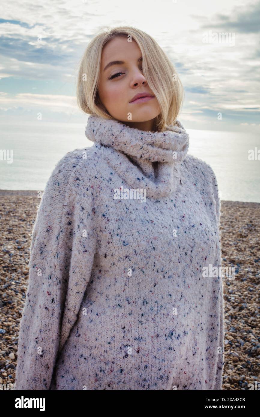 Junge Frau im Winter am Kiesel-Strand Stockfoto