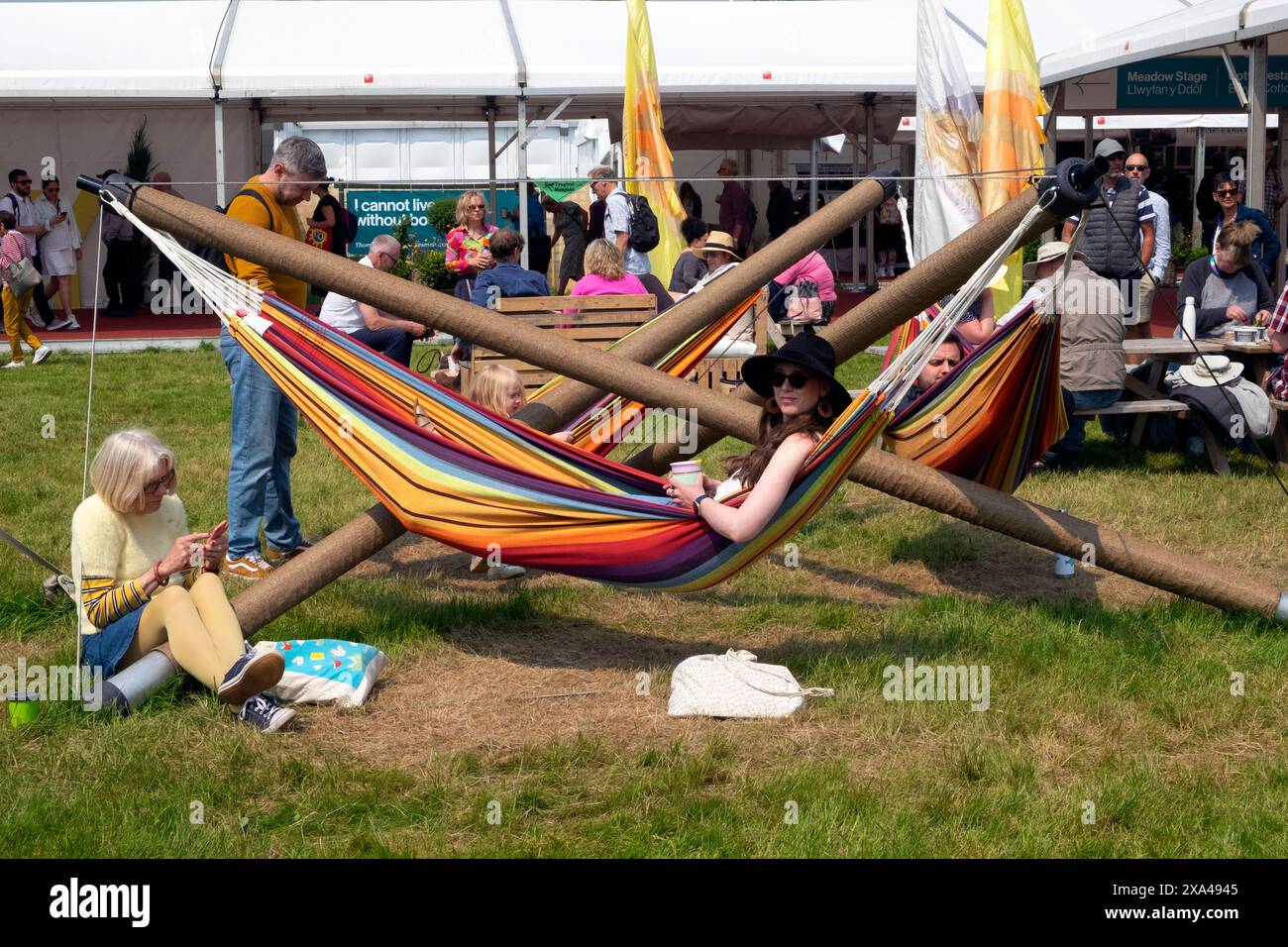 Besucher, der auf dem Hay Festival Hay-on-Wye Wales Großbritannien Großbritannien Großbritannien KATHY DEWIT eine junge Frau mit schwarzem Sonnenhut in der Hängematte sieht Stockfoto