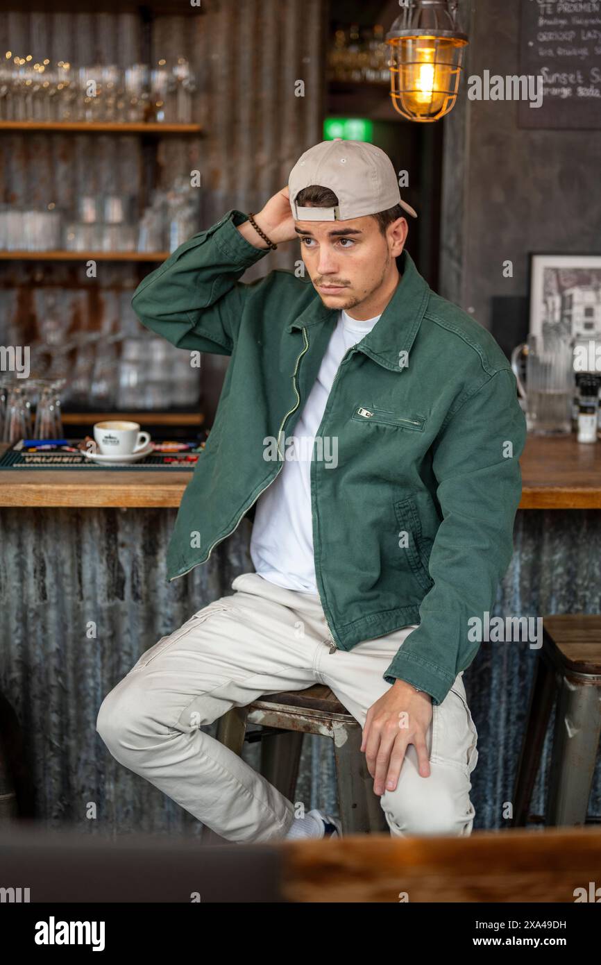 Mann posiert in einem lässigen Outfit in einem Café. Stockfoto