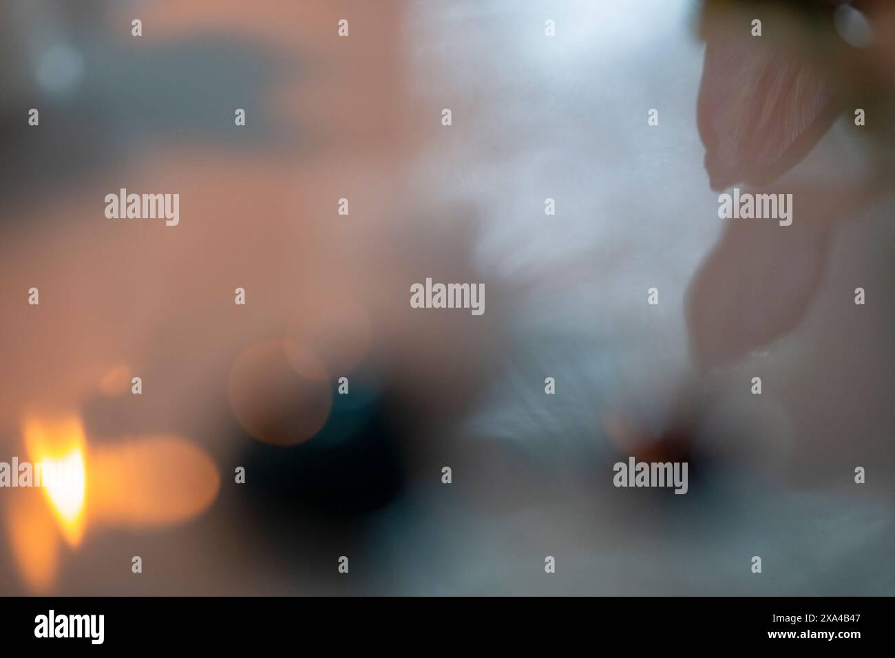 Ein verschwommenes Bild, das eine vage Silhouette einer Person durch eine dampfende oder nebelige Atmosphäre aufnimmt, wobei weiche Lichtquellen zur Atmosphäre beitragen. Stockfoto