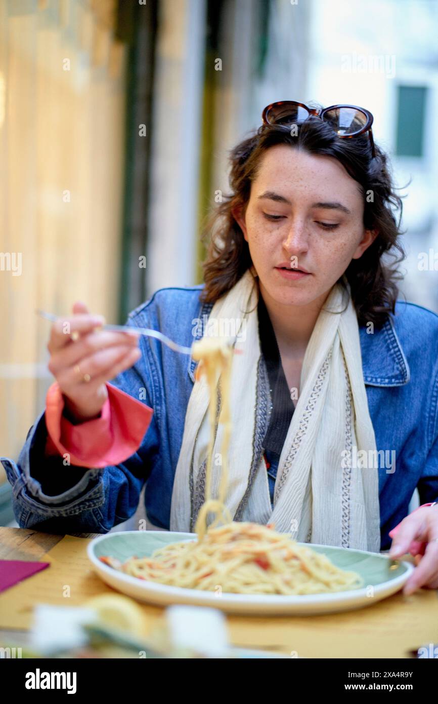 Frau genießt einen köstlichen Teller Spaghetti in einem Restaurant im Freien Stockfoto