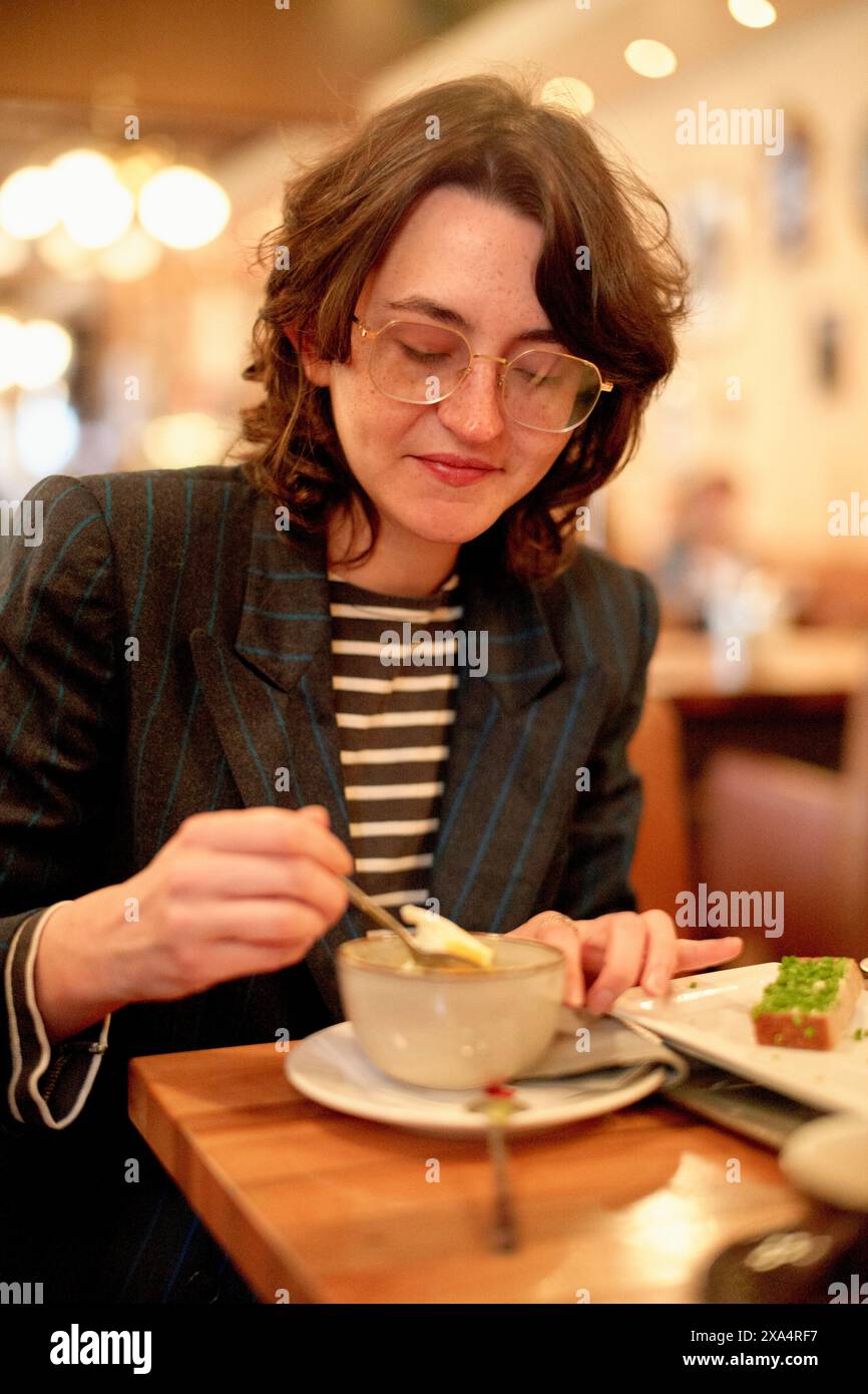 Frau genießt eine Mahlzeit in einem gemütlichen Restaurant. Stockfoto