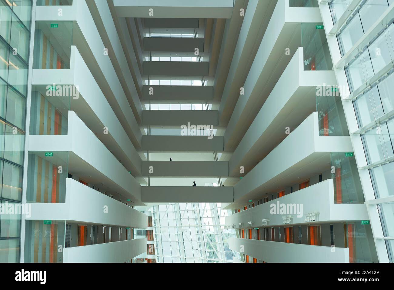 Moderne architektonische Innenausstattung eines Gebäudes mit symmetrischen Böden, Glasfassade und Tageslicht. Stockfoto