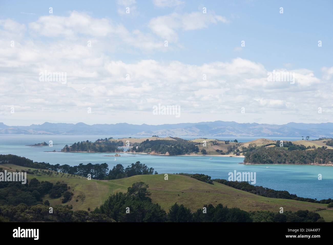 Malerische Aussicht auf eine üppige Küstenlandschaft mit klarem blauem Wasser unter einem teilweise bewölkten Himmel. Stockfoto