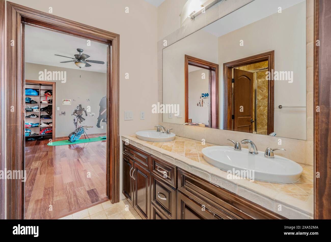 Ein Badezimmer mit Waschbecken, zwei Spiegeln und gefliestem Boden Stockfoto