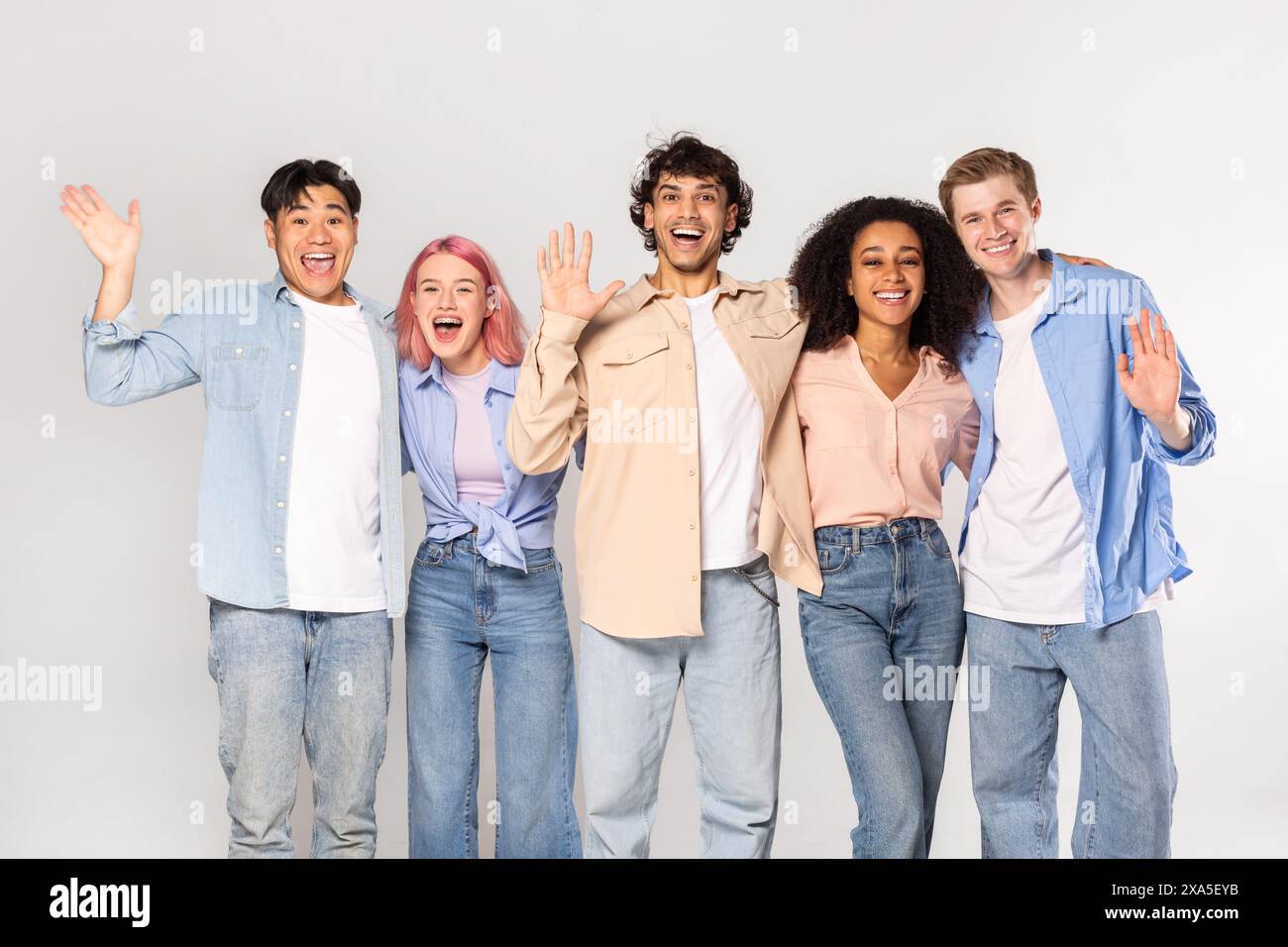 Verschiedene Gruppe glücklicher junger Erwachsener posiert vor weißem Hintergrund Stockfoto