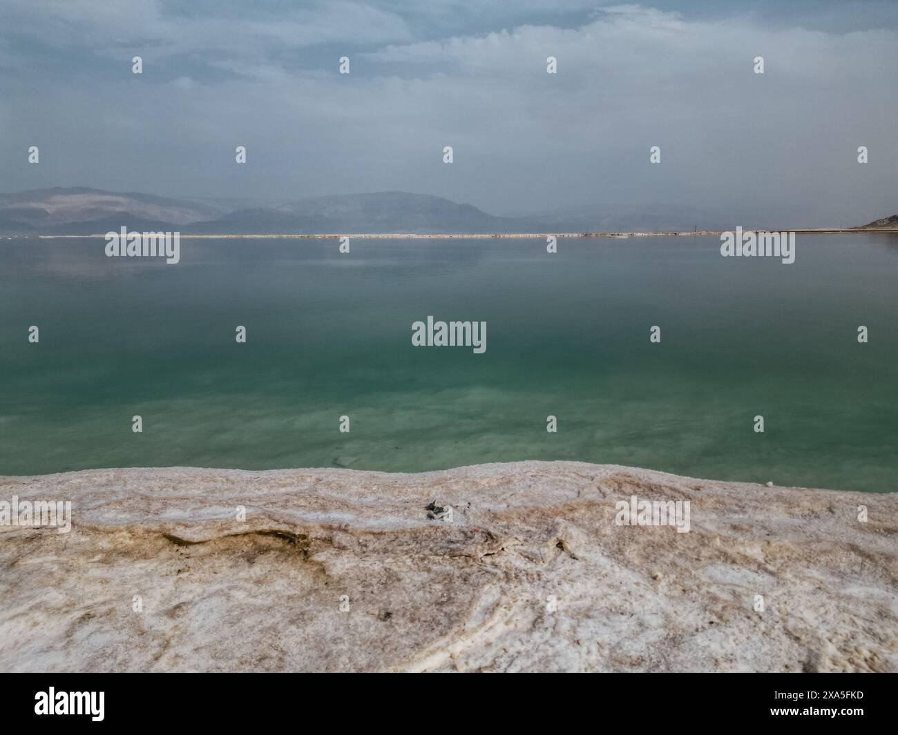 Ein bewölkter Tag am Toten Meer mit Bergen im Hintergrund. Stockfoto