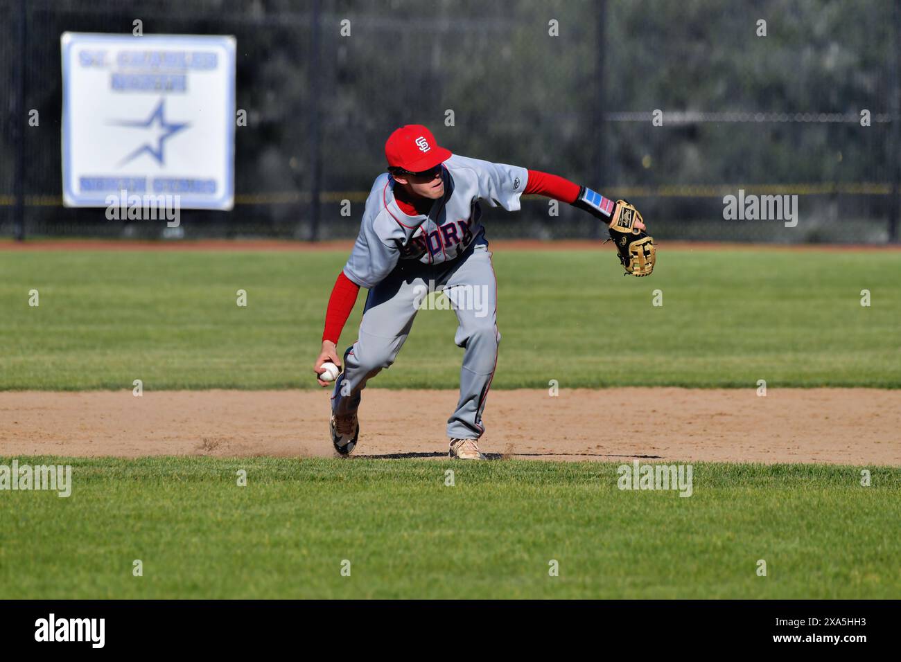 Illinois, USA. Zweiter Baseman, der einen abgelenkten Ball mit bloßer Hand aufnimmt, bevor er den Teig bei der ersten Base auswirft. Stockfoto