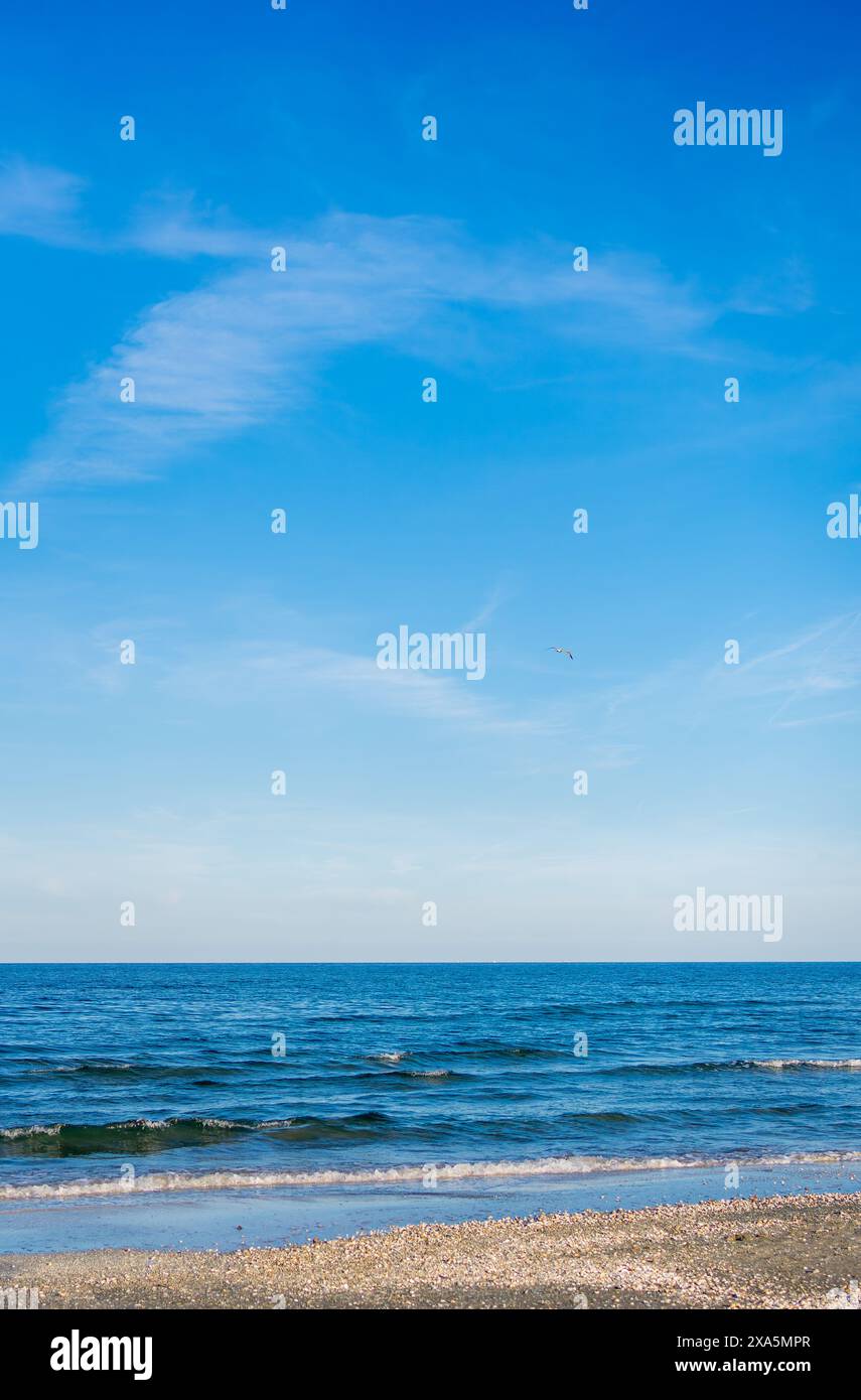 Blauer Himmel und Ozean mit flauschigen Wolken darüber Stockfoto