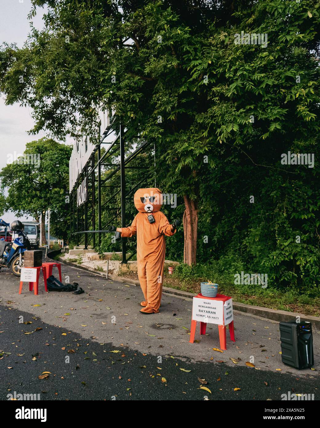 Ein Mann, der ein Bärenkostüm trägt, tanzt am Wang Kelian Aussichtspunkt. Stockfoto