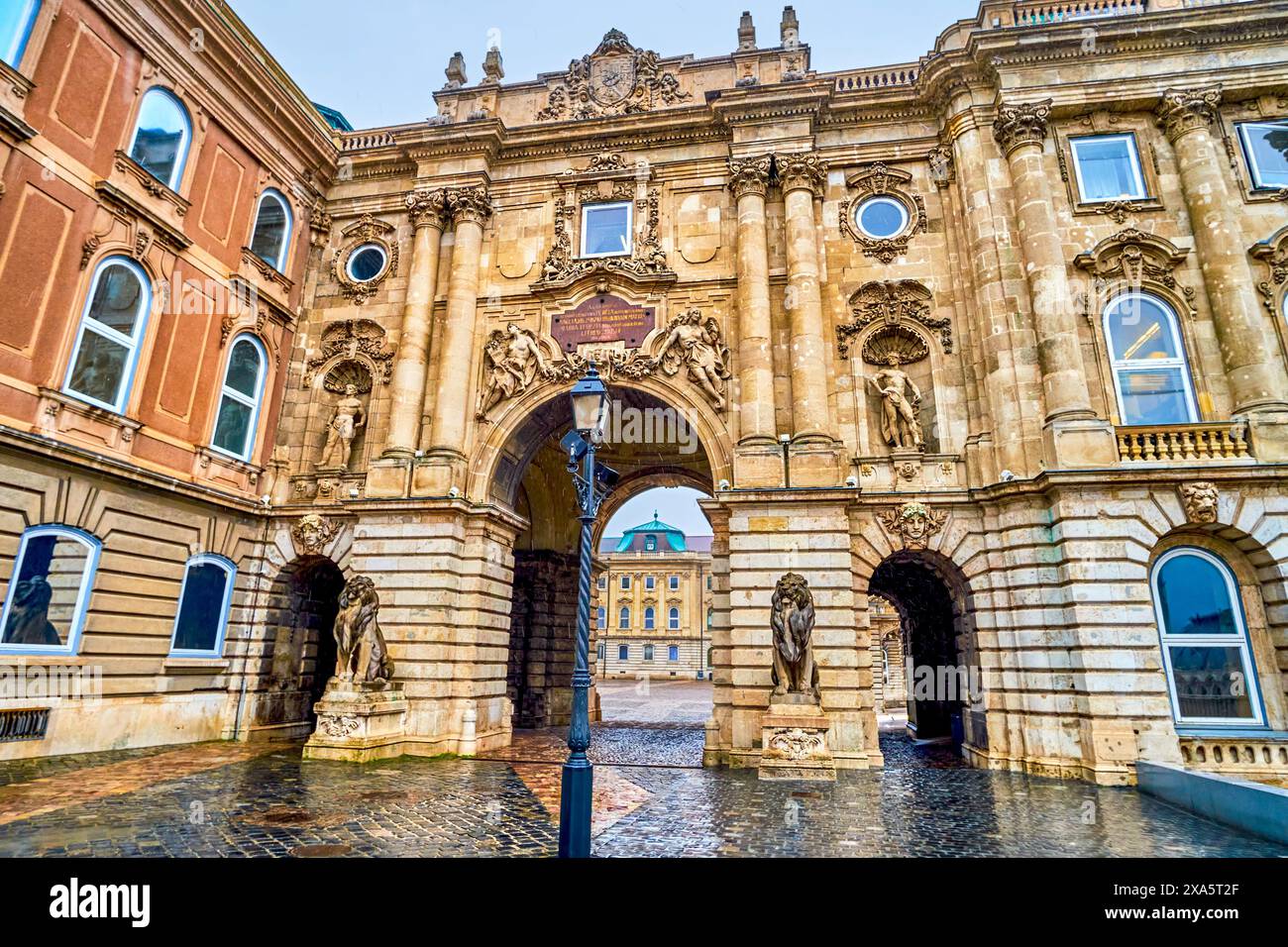Das Tor zum Löwenhof mit Skulpturen sitzender Löwen im Schloss Buda, Budapest, Ungarn Stockfoto