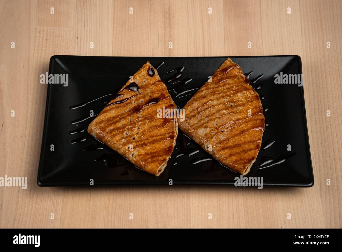 Eine Nahaufnahme von Pfannkuchen mit Sirup auf einem Teller serviert auf einem Tisch Stockfoto