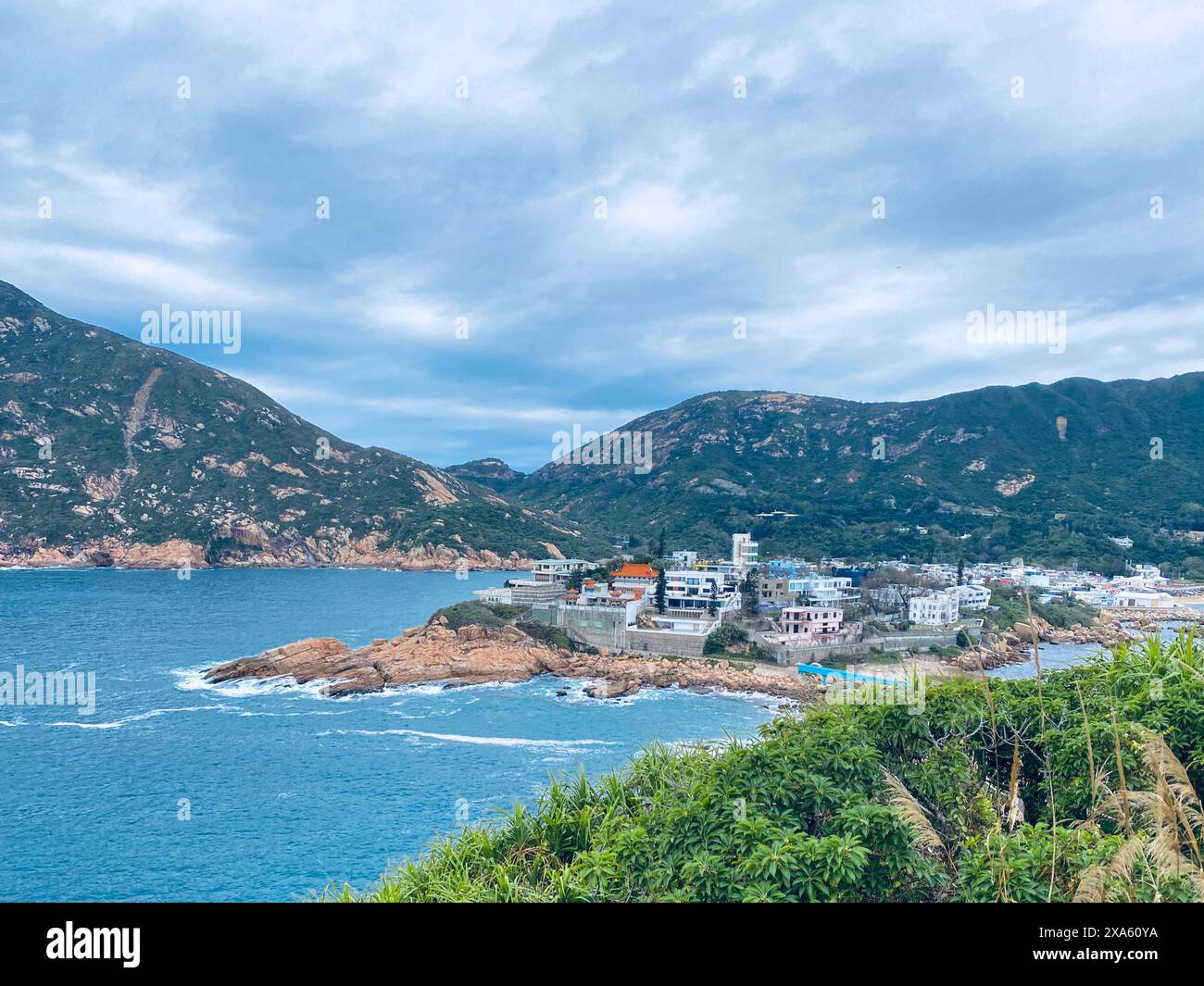 Das malerische Shek O Village an der Küste und der Dragon's Back Mountain mit der Küste der roten Felsen Stockfoto