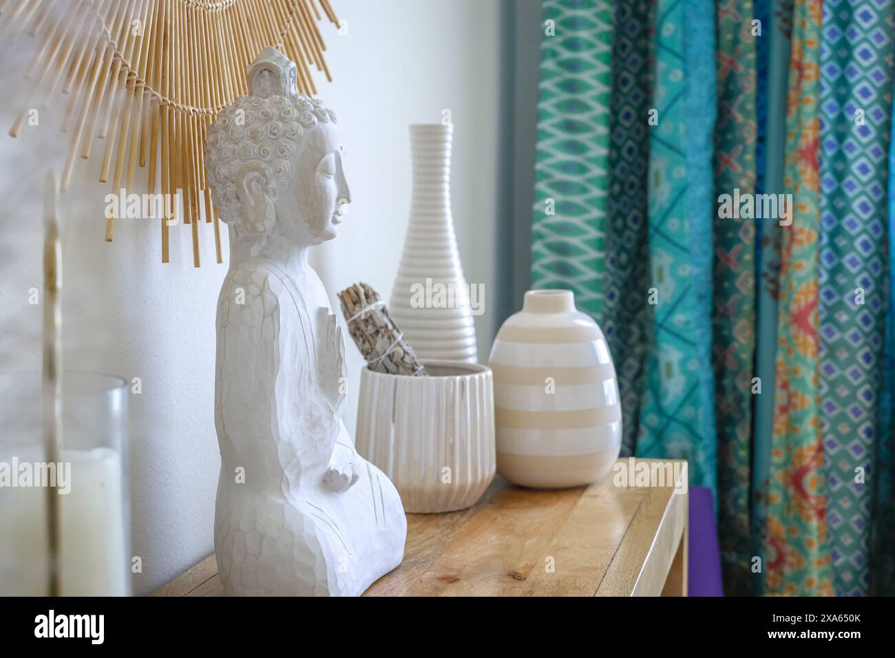 Ein Regal in einem friedlichen Meditationsstudio mit Kerzen, Statuen und Töpferwaren für ein wohltuendes Erlebnis Stockfoto