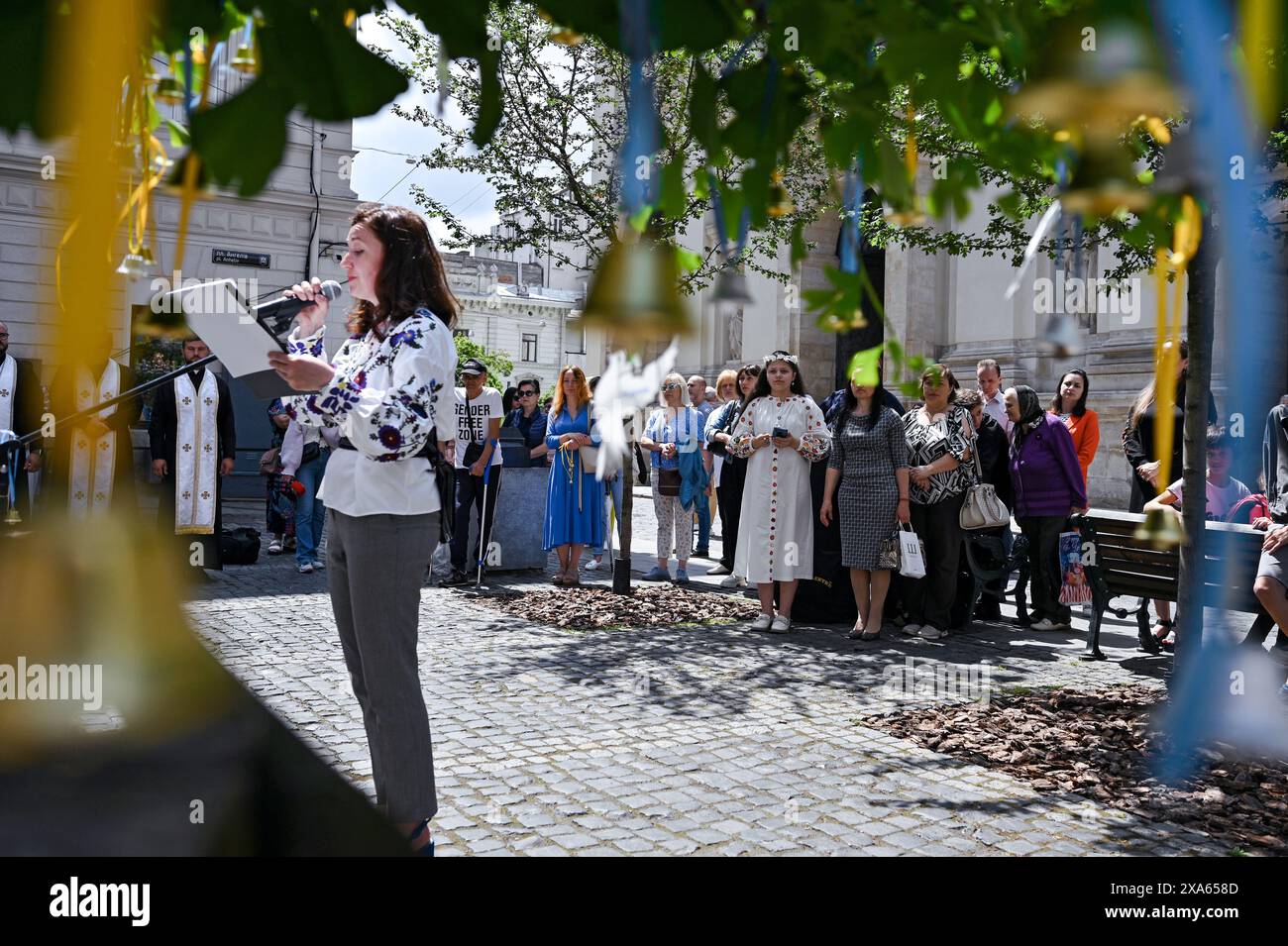 LEMBERG, UKRAINE – 04. JUNI, 2024 - Teilnehmer der Kampagne „Children’s Voices“, die am Tag des Gedenkens an die Kinder organisiert wurde, die infolge der bewaffneten Aggression der Russischen Föderation gegen die Ukraine starben, binden Glocken an ein Seil auf dem Ploschcha Anheliv Platz in der Nähe der Garnisonkirche der Heiligen Apostel Peter und Paul von der UGCC, Lemberg, Westukraine Stockfoto