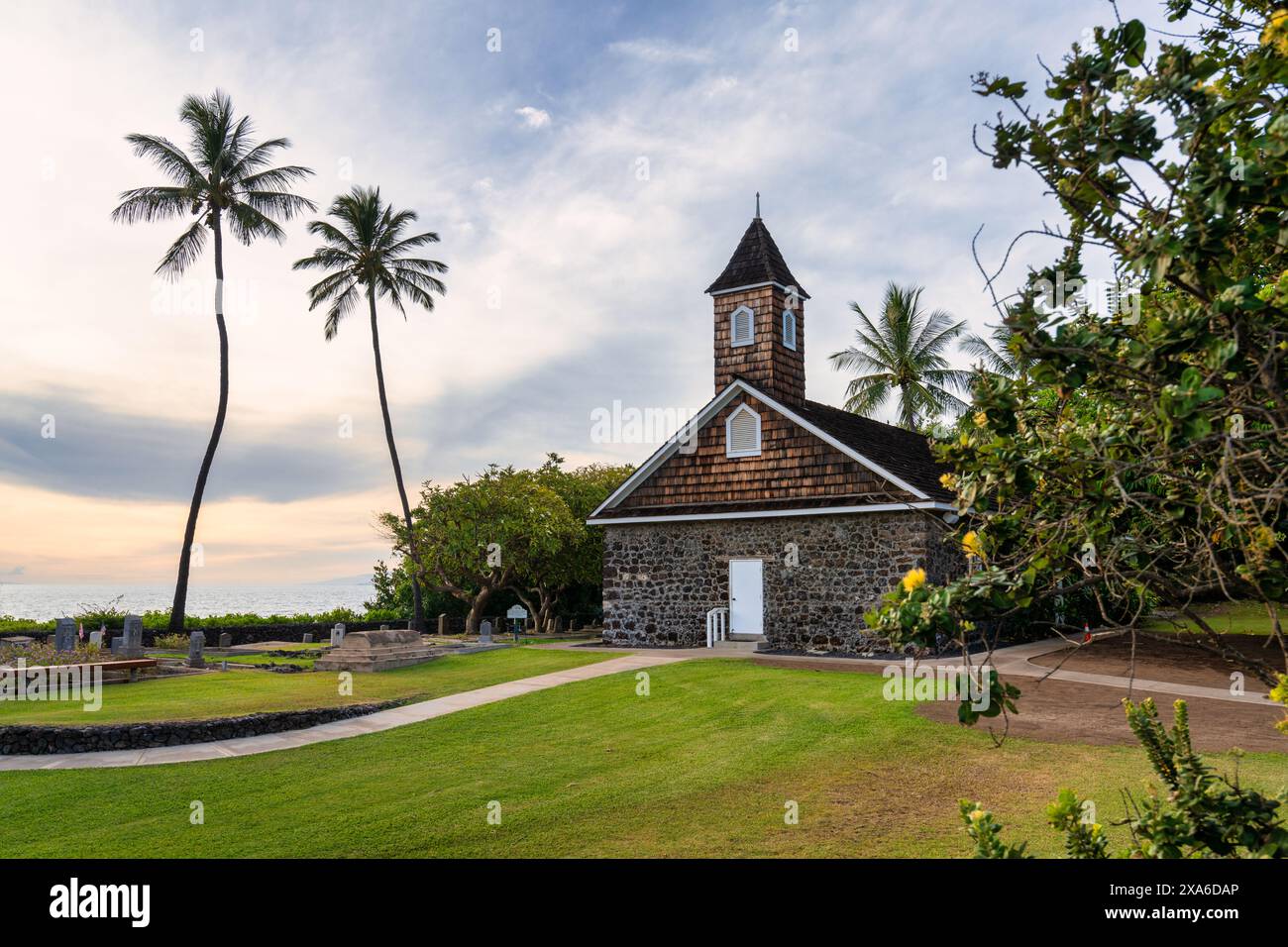 Eine malerische Kirche auf einem grasbewachsenen Feld mit Palmen in Maui, Hawaii Stockfoto