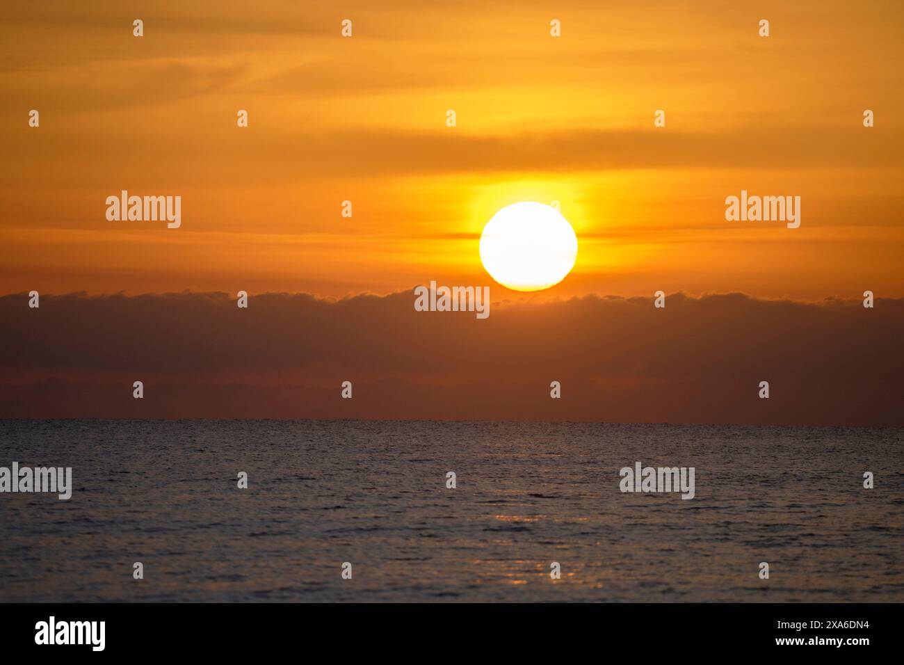 Nahaufnahme des Sonnenaufgangs durch die Wolken bei Sonnenaufgang an den Stränden von Mojacar. Urlaub und Sonnenaufgänge am Strand Stockfoto
