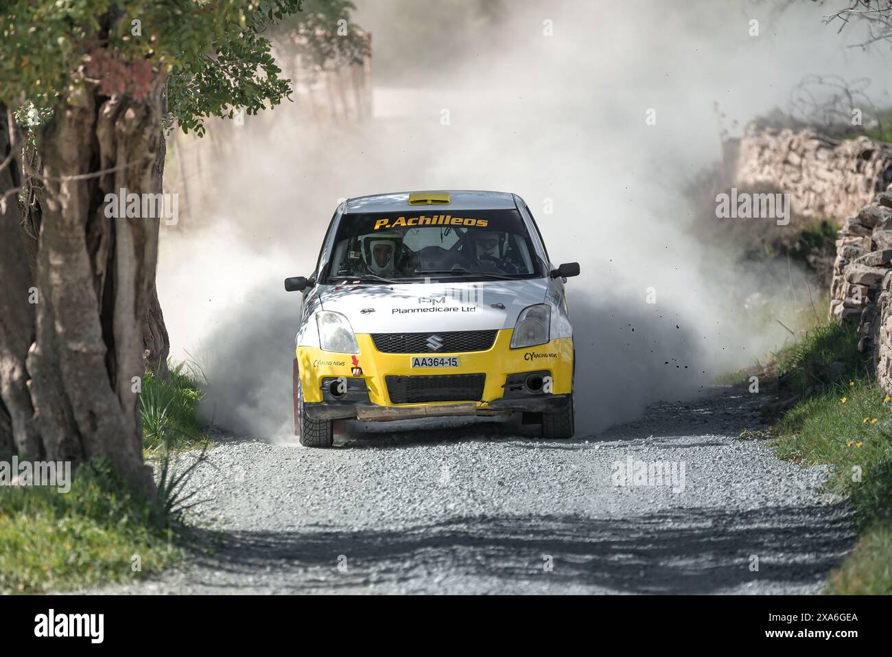 Anogyra, Zypern - 29. Januar 2023: Suzuki Swift Sport MK4 Rallye-Car-Rennen auf einer staubigen Schotterstraße, umgeben von üppigem Grün Stockfoto