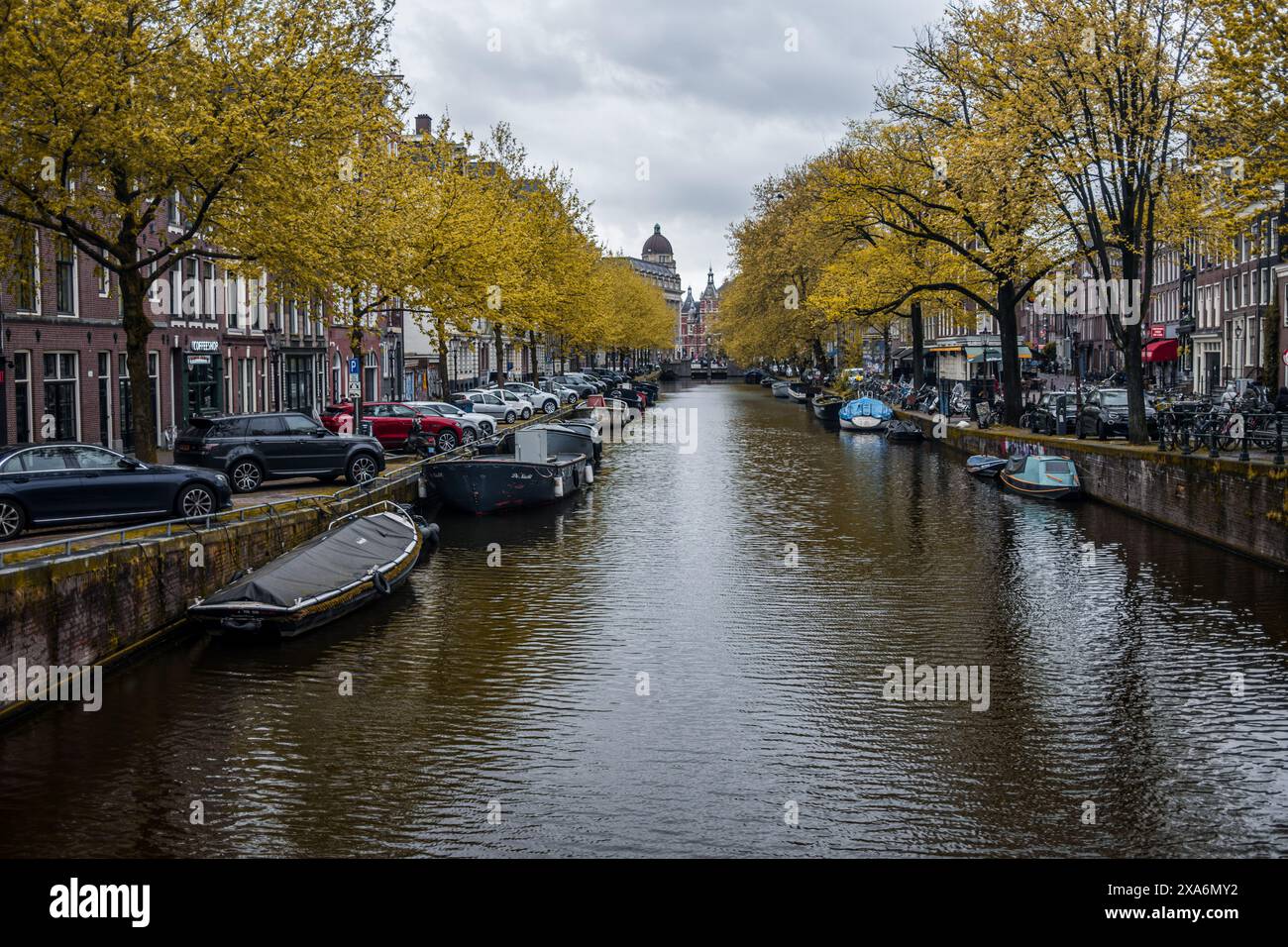 Ein bezaubernder Blick auf einen Kanal, gesäumt von Booten und historischen Gebäuden in Amsterdam, Niederlande. Stockfoto