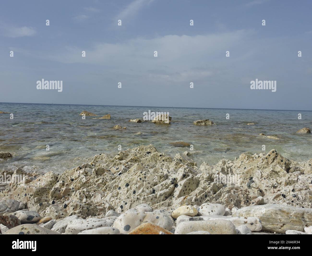 The Rocks bedeckt mit Sand und Kieselsteinen an einem Strand Stockfoto
