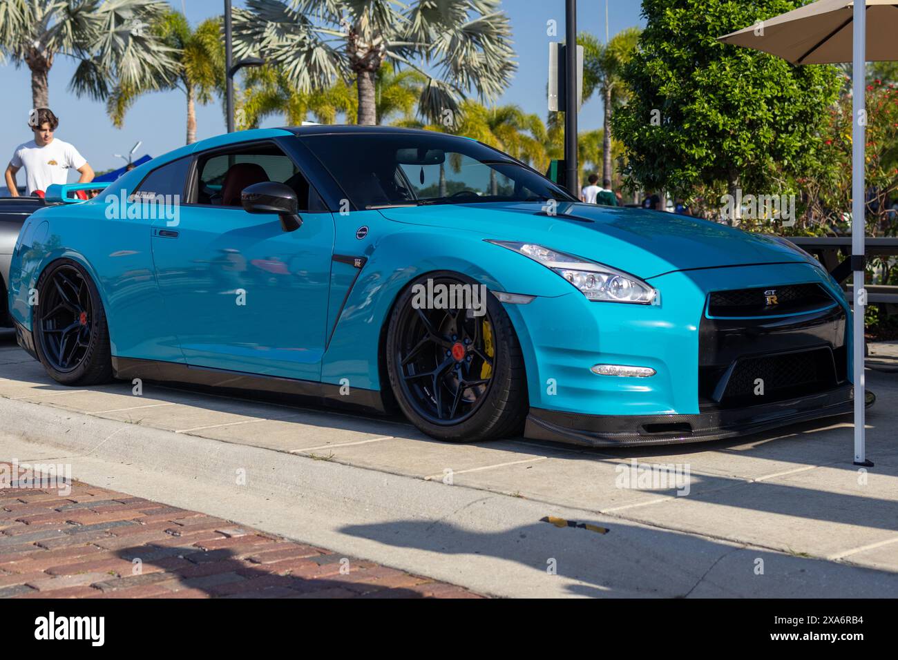 Der R35 GTR parkt bei einem Auto und der Kaffee trifft sich mit kundenspezifischen Felgen. Stockfoto