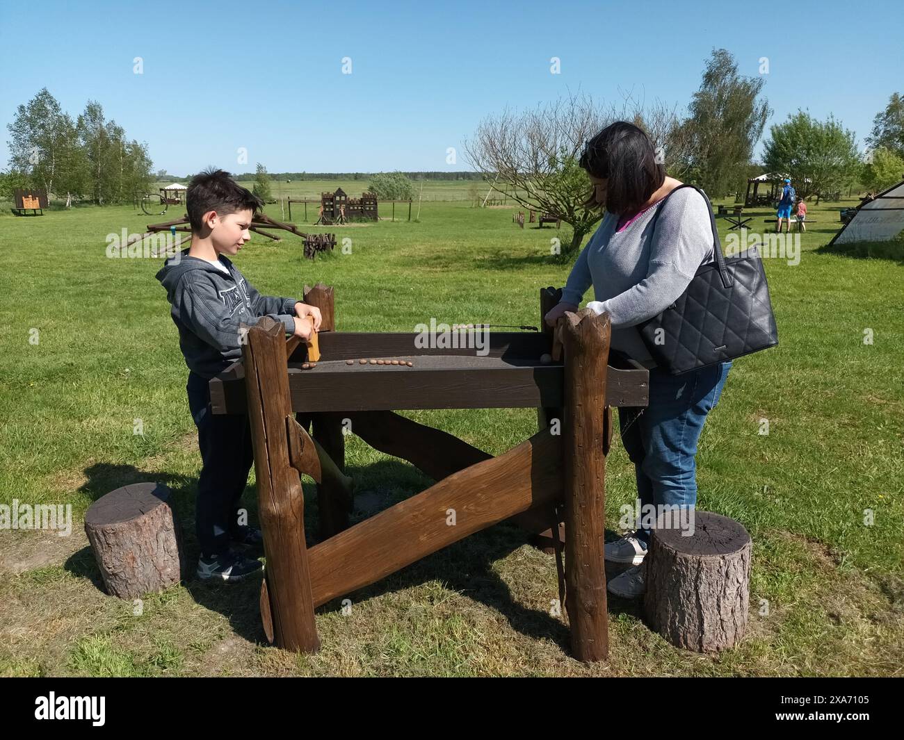 Eine Frau und ein Kind spielen draußen an einem Tisch Stockfoto