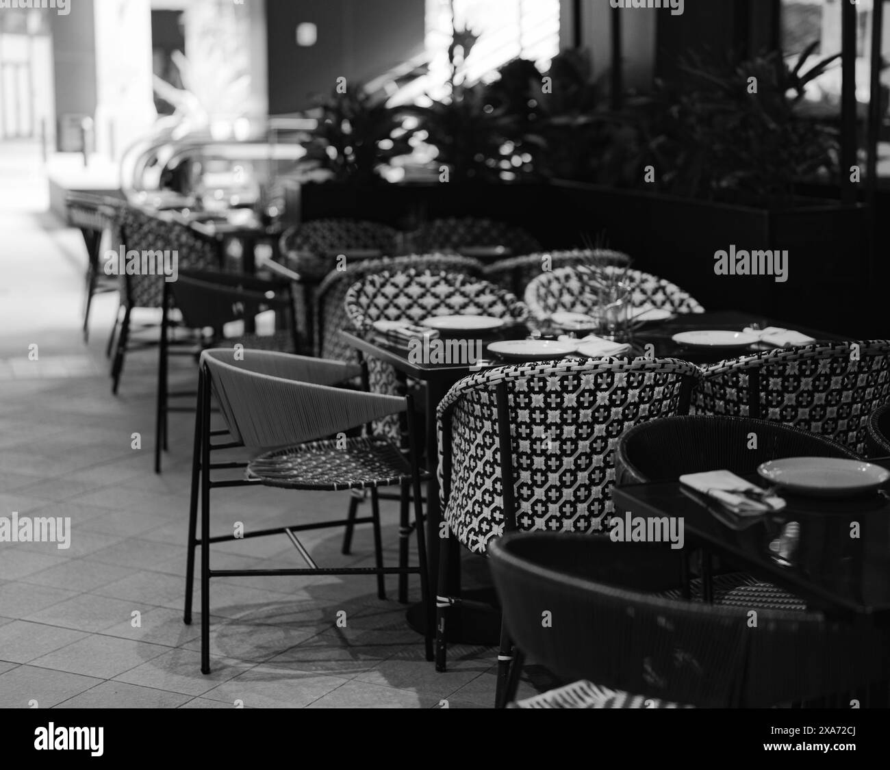 Eine wunderschön eingerichtete Terrasse mit Tischen in Graustufen Stockfoto