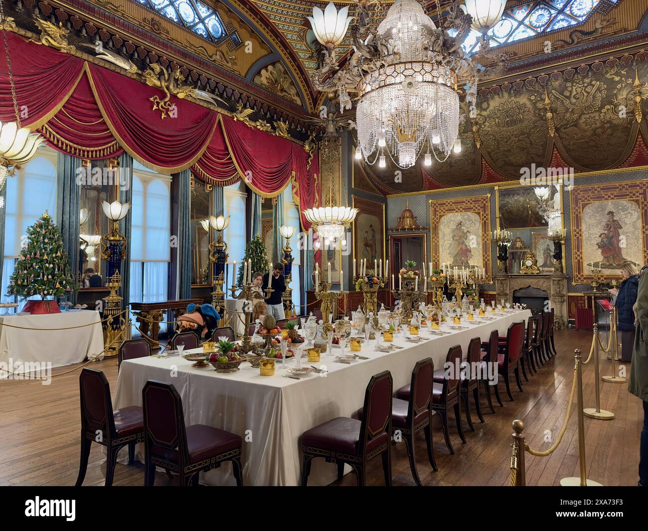 Eleganter Speisesaal mit Tischen und goldfarbener Wanddekoration Stockfoto