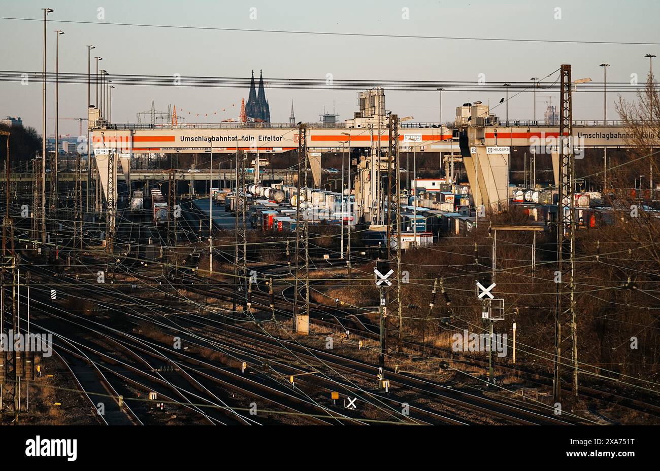 Ein Bahnhofbahnhof mit Zügen auf Gleisen und Ampeln im Hintergrund in Köln. Stockfoto