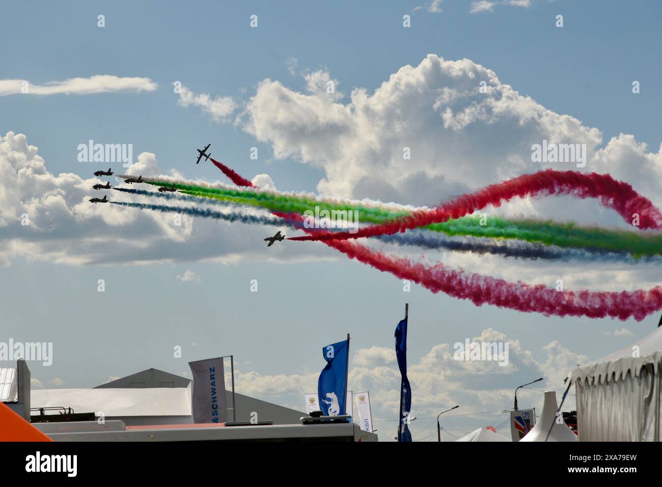 Bunte Rauchpfade hinter mehreren Flugzeugen am Himmel Stockfoto