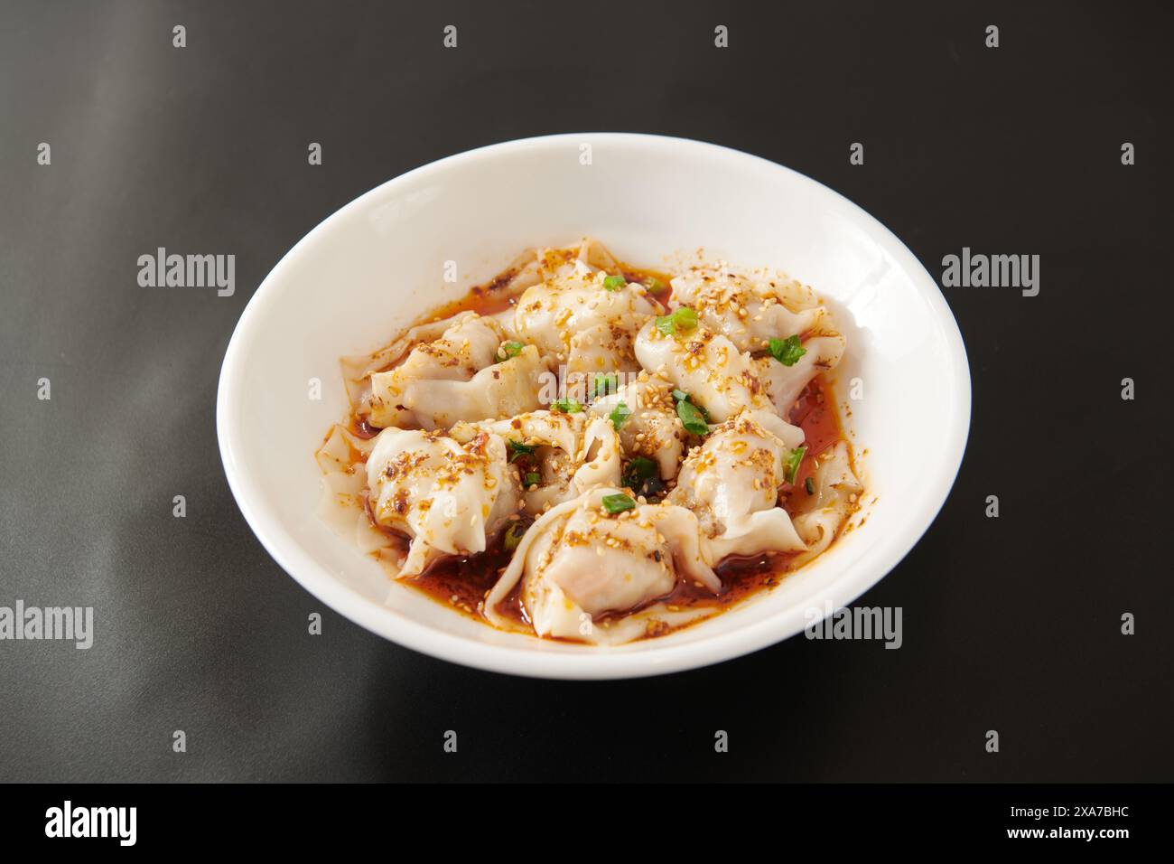 Eine Nahaufnahme von Ravioli in einer Schüssel auf einem schwarzen Tisch Stockfoto