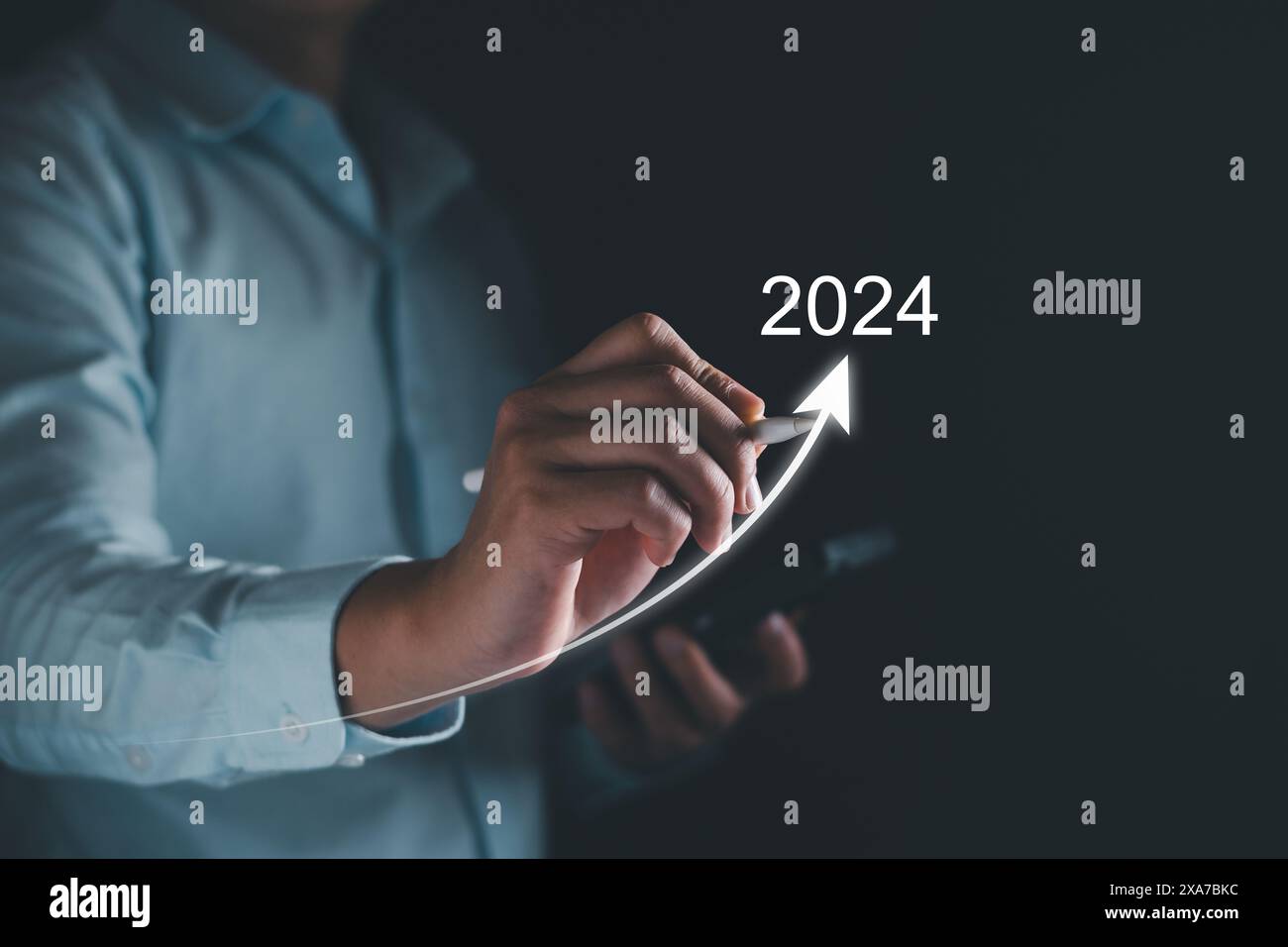 Neujahrsziel 2024. Tippen Sie mit der Hand auf das Zielsymbol, Ziel 2023 bis 2024 für die Vorbereitung Happy New Year, Start New Year. Planung, Chance, Herausforderung Stockfoto