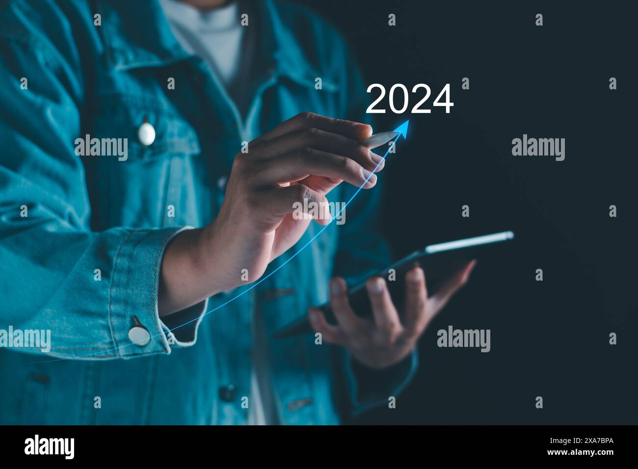 Neujahrsziel 2024. Tippen Sie mit der Hand auf das Zielsymbol, Ziel 2023 bis 2024 für die Vorbereitung Happy New Year, Start New Year. Planung, Chance, Herausforderung Stockfoto