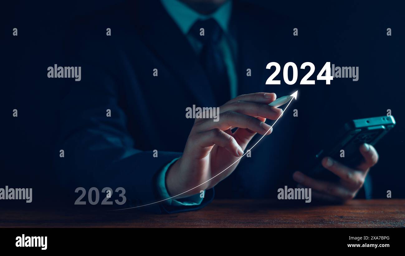 Neujahrsziel 2024. Tippen Sie mit der Hand auf das Zielsymbol, Ziel 2023 bis 2024 für die Vorbereitung Happy New Year, Start New Year. Planung, Chance, Herausforderung Stockfoto