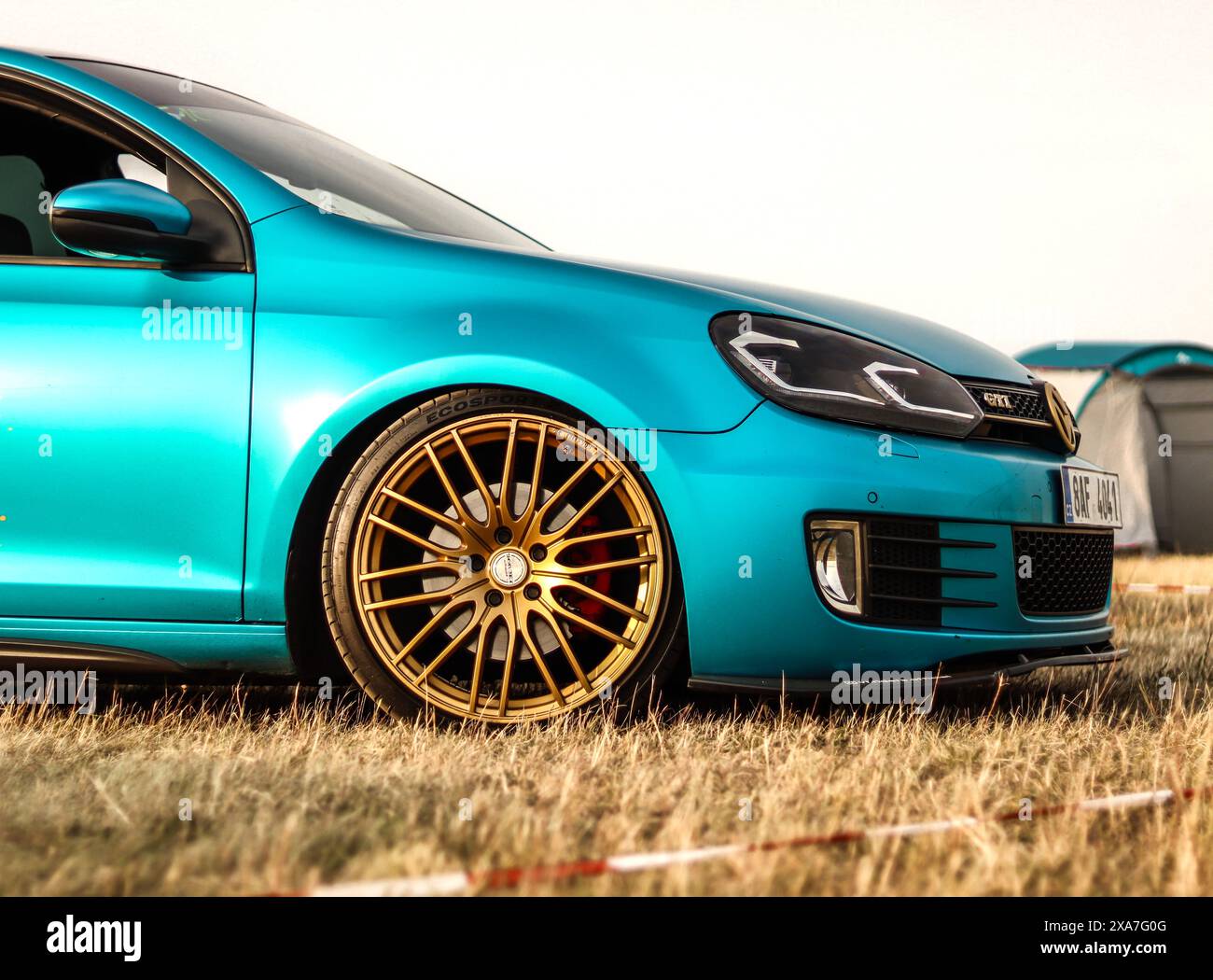 Ein türkisfarbenes Auto mit goldenen Felgen und Rädern Stockfoto