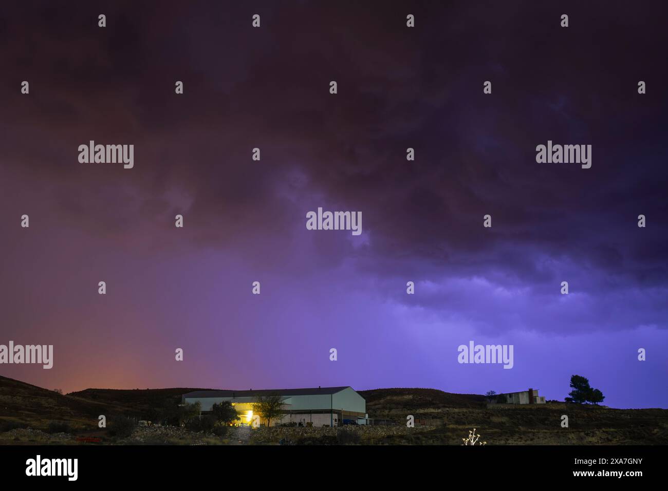 Intensiver Sommersturm beleuchtet den Himmel mit einem elektrischen Blau, das den starken Blitz hervorhebt Stockfoto