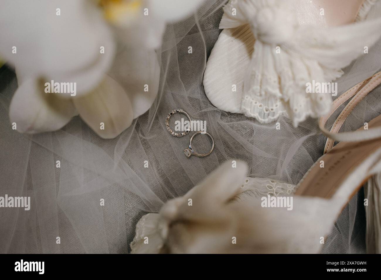 Die Brautschuhe, der Blumenstrauß und die goldenen Ringe am Hochzeitstag Stockfoto