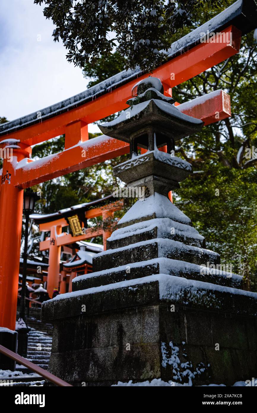 Ein traditionelles japanisches Tor im alten Stil und Tempel, die mit seltenem Winterschnee bedeckt sind, am Fushimi Inari Schrein in Kyoto Japan. Stockfoto