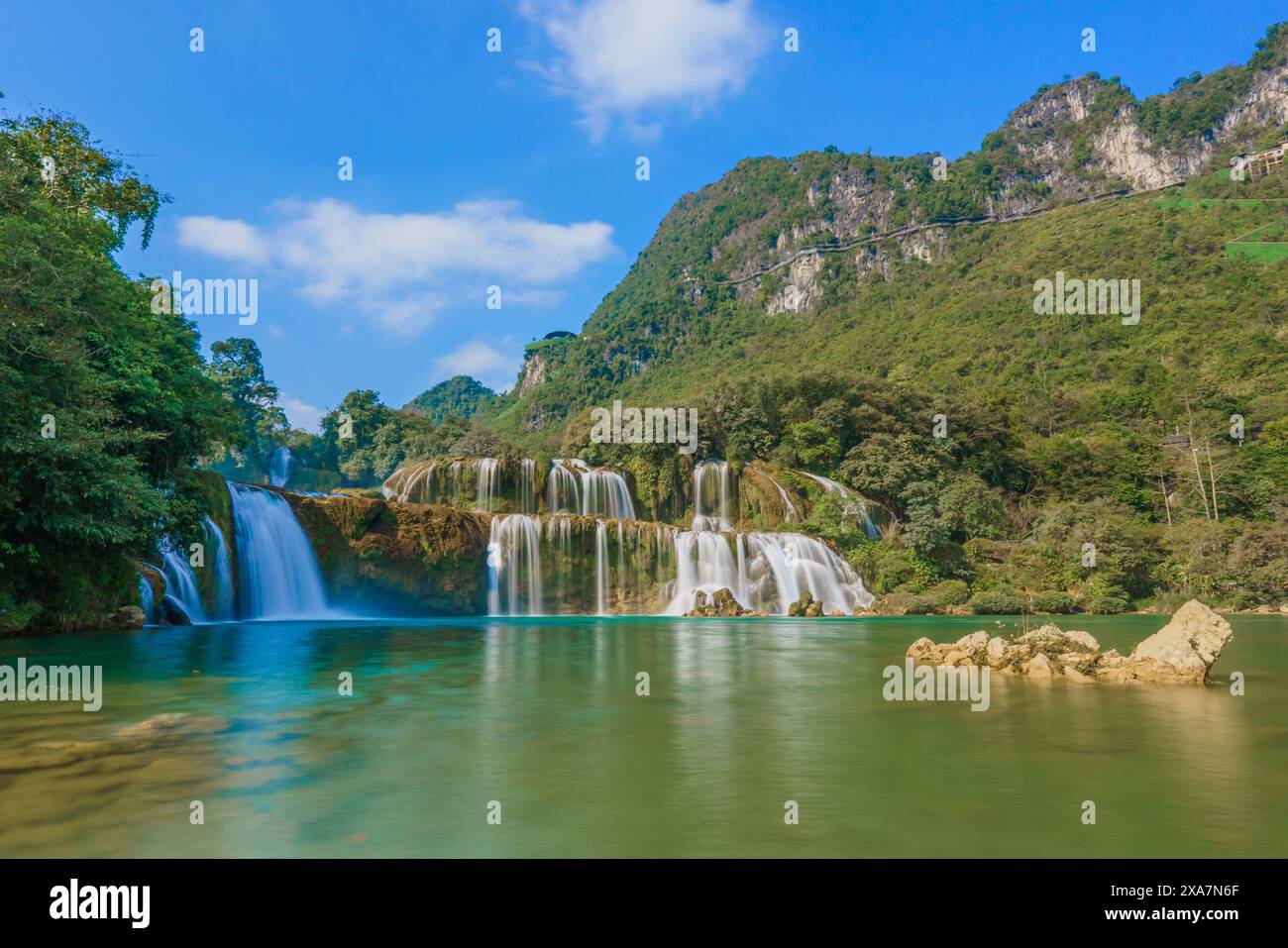 Die berühmten Hualong Falls in einem Bergdschungel von Lao mit kaskadierenden Wasserfällen neben den Bergen Stockfoto