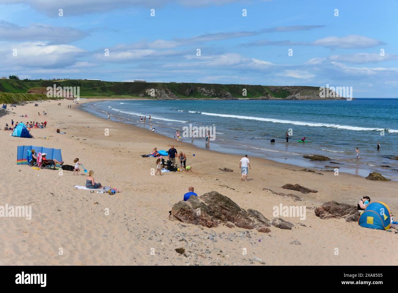 Portknockie, Moray Firth Bay, Schottland, Vereinigtes Königreich, Europa, ein belebter Strand mit Leuten, die sich entspannen und in Zelten zelten, während das Meer sanft gegen das Meer schlägt Stockfoto