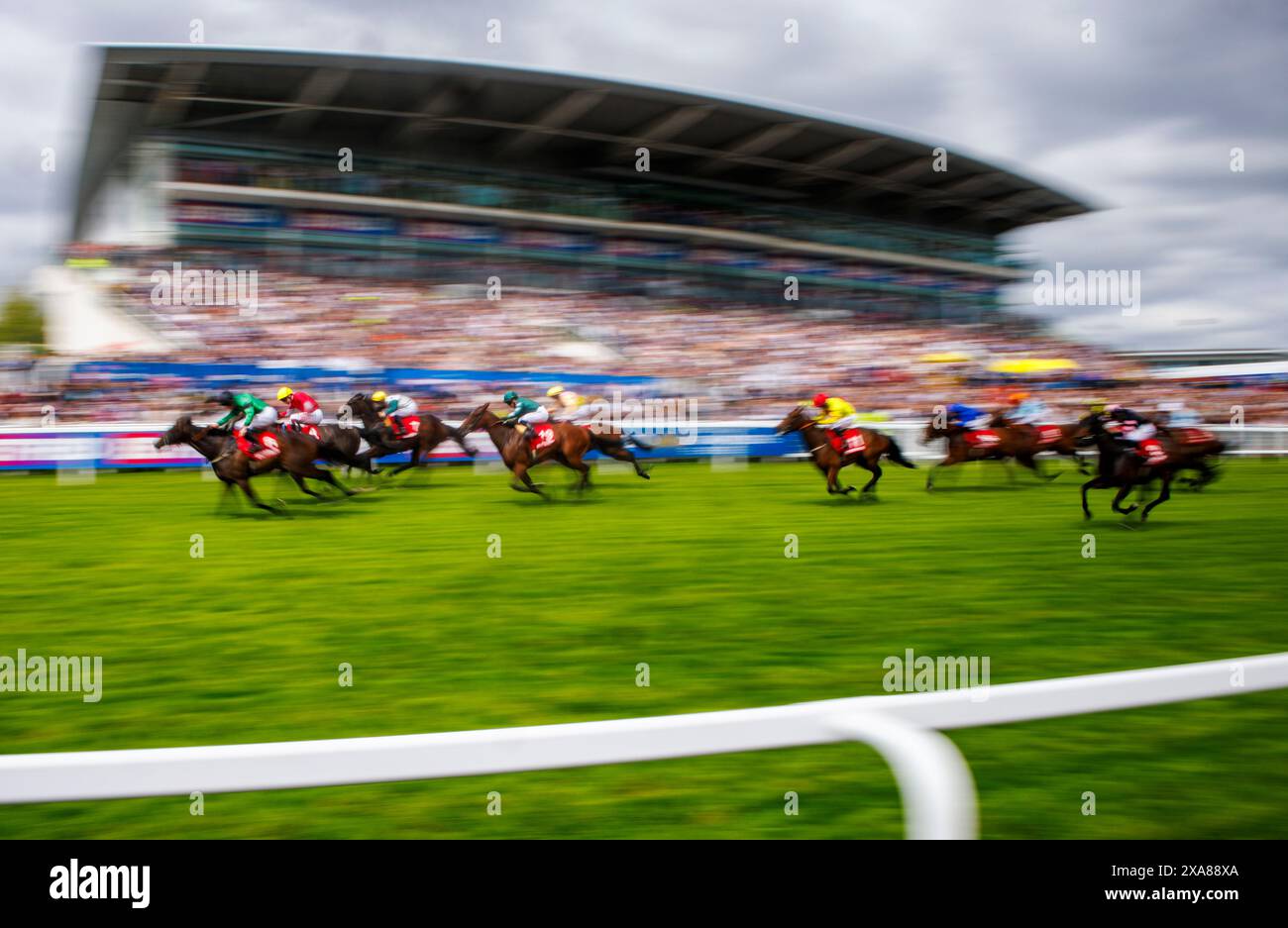 Pferde passieren die Haupttribüne beim Epsom Derby Festival. Das Derby ist eines der klassischen Pferderennen des Jahres. Stockfoto