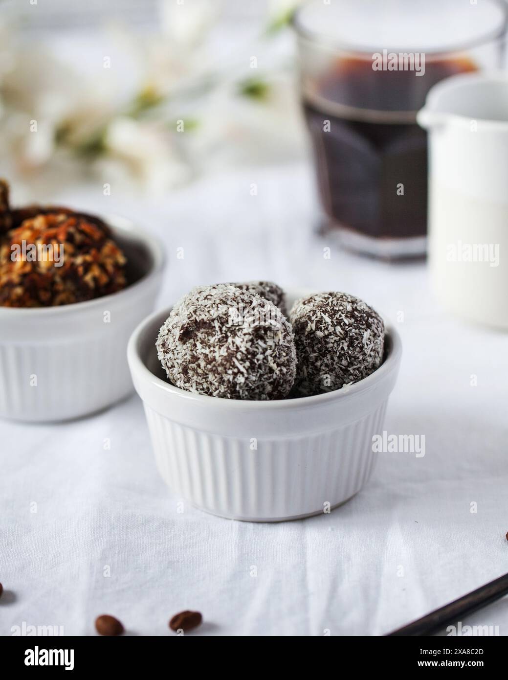 Stellen Sie Schokoladenbonbons mit Kokosflocken in einer Keramikschale her Stockfoto