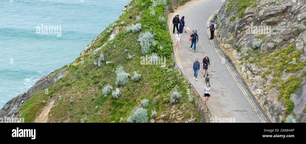 Ein Panoramablick von Urlaubern Besucher, die entlang der Zufahrt zum GT Western Beach in Newquay in Cornwall in Großbritannien spazieren. Stockfoto