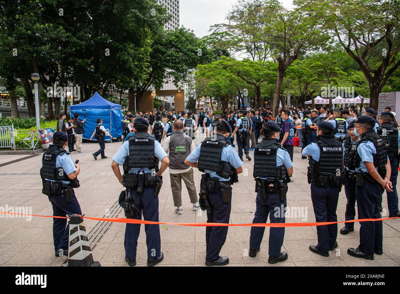 Hongkong, China. Juni 2024. Eine große Gruppe von Polizeibeamten sperrt ein Gebiet um einen inhaftierten Mann im Victoria Park, Causeway Bay. Es gab eine starke Polizeipräsenz im Victoria Park, dem traditionellen Ort einer Gedenkfeier für diejenigen, die während des Durchgriffs der chinesischen Regierung auf dem Platz des Himmlischen Friedens am 4. Juni 1989 ihr Leben verloren haben. Die Polizei verhaftete, durchsuchte und entfernte mehrere Personen, die versuchten, sich das Ereignis zu merken. (Foto: Ben Marans/SOPA Images/SIPA USA) Credit: SIPA USA/Alamy Live News Stockfoto