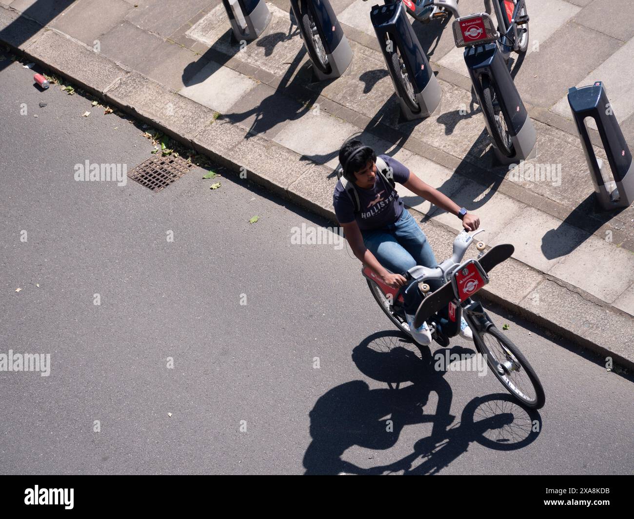 Junger Mann mit Santander Leihfahrrad an der Dockingstation im Zentrum von London vorbei Stockfoto