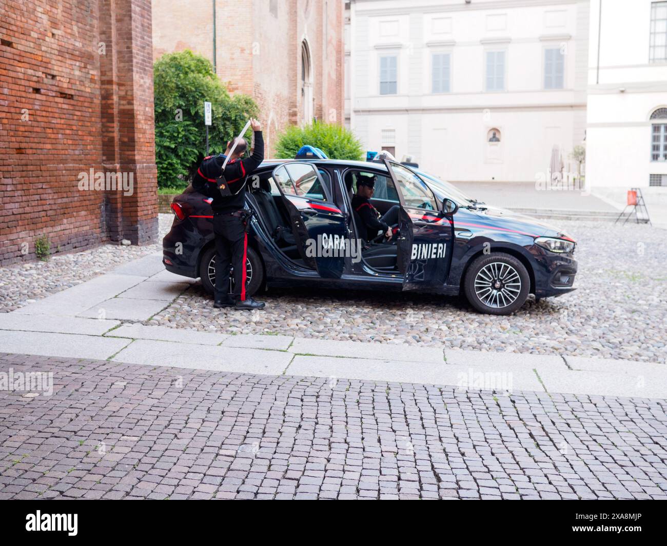 Cremona, Italien - 27. Mai 2024 zwei Mitglieder der Carabinieri, italiens nationale Militärpolizei, verlassen ihren Streifenwagen in einem Hof, vorbereitet Stockfoto